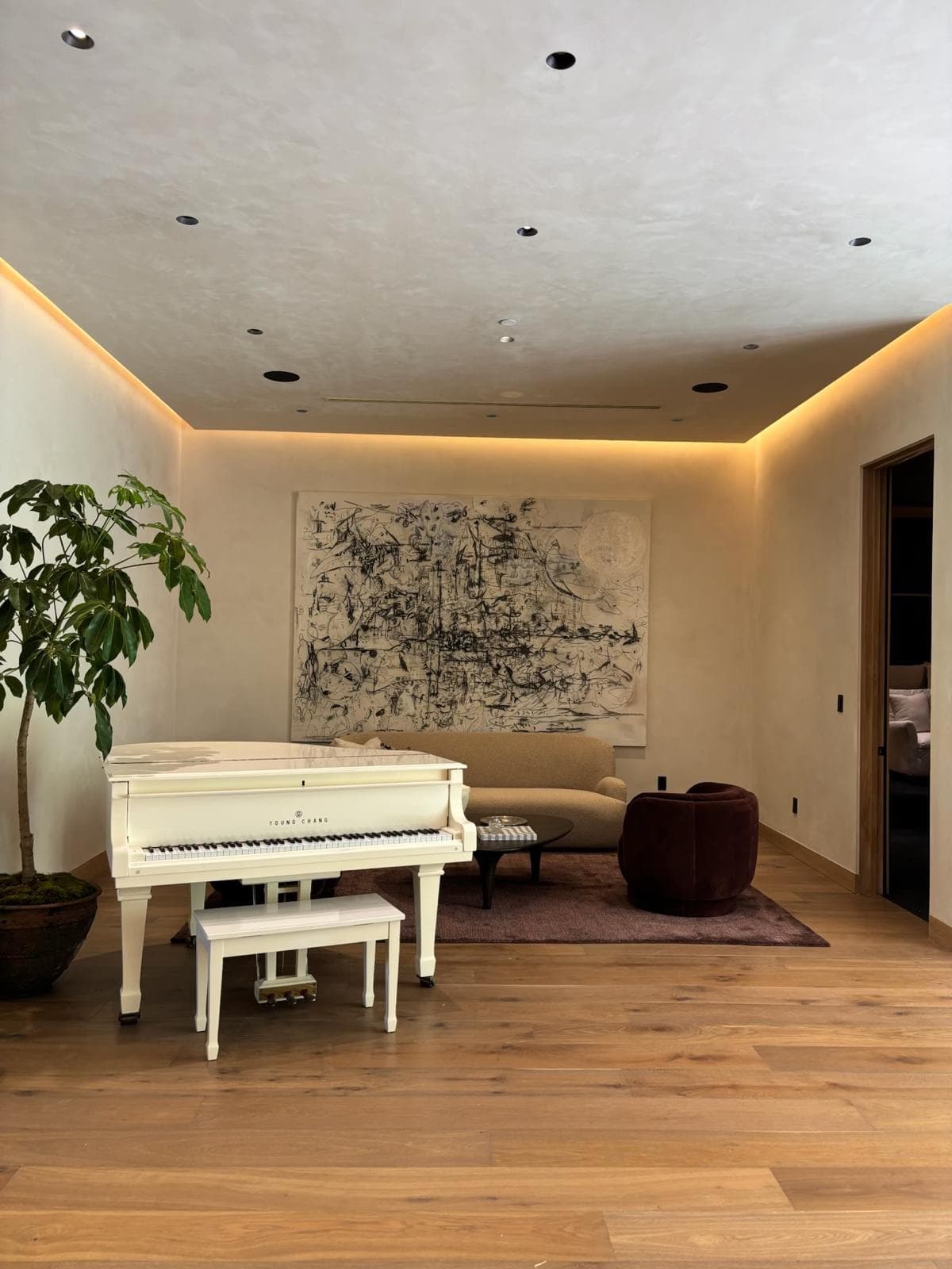 Art-filled private interior with a white piano